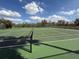 The outdoor tennis court is green, the lines are crisp and white, and the net is up at 5345 Bloomfield Blvd, Lakeland, FL 33810