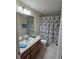 Neat bathroom featuring a vanity with mirror, shower-tub with curtain, and tile floor at 5407 Quarry Rock Rd, Lakeland, FL 33809