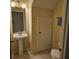Compact bathroom with a pedestal sink, tiled floor, and a closed door, offering a functional space at 5407 Quarry Rock Rd, Lakeland, FL 33809