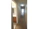 Hallway leading to a bathroom and other rooms, with neutral carpeting and beige walls at 5407 Quarry Rock Rd, Lakeland, FL 33809