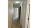 Hallway with beige walls, neutral carpet, closet, and doors leading to other rooms at 5407 Quarry Rock Rd, Lakeland, FL 33809