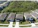 Aerial view of home with manicured lawn, a driveway, and backing to wooded area at 5531 Keaton Springs Dr, Lakeland, FL 33811