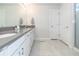 Bright bathroom with white cabinets, gray countertop, walk-in shower, and tile flooring at 5531 Keaton Springs Dr, Lakeland, FL 33811