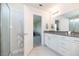 Bright bathroom with white cabinets, gray countertop, walk-in shower, and tile flooring at 5531 Keaton Springs Dr, Lakeland, FL 33811
