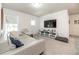 Bright living room featuring gray carpet, white walls, large TV, and comfortable white sectional sofa at 5531 Keaton Springs Dr, Lakeland, FL 33811
