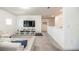 Bright living room featuring gray carpet, white walls, large TV, and comfortable white sectional sofa at 5531 Keaton Springs Dr, Lakeland, FL 33811
