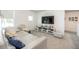 Bright living room featuring gray carpet, white walls, large TV, and comfortable white sectional sofa at 5531 Keaton Springs Dr, Lakeland, FL 33811