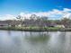 Waterfront homes overlook a tranquil lake lined with mature trees on a sunny day, offering a peaceful retreat at 5639 Water Oak Ln, Mulberry, FL 33860