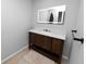 Modern bathroom with a dark wood vanity, white countertop, and an illuminated mirror at 5716 Gibson Shores Dr, Lakeland, FL 33809
