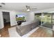 Comfortable living room featuring a gray leather sofa, a television, and sliding glass doors to the outside at 5716 Gibson Shores Dr, Lakeland, FL 33809
