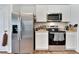 Kitchen showcasing stainless steel appliances, granite countertops, white cabinets, and wood-look flooring at 6296 Dolostone Dr, Lakeland, FL 33811