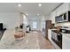 A kitchen featuring stainless steel appliances, granite countertops, white cabinets, and wood-look flooring at 6296 Dolostone Dr, Lakeland, FL 33811