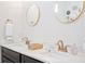 Modern bathroom featuring a marble countertop, dual sinks with gold hardware, and a decorative round mirror at 631 W Park St, Lakeland, FL 33803