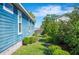 Scenic view of a side yard with lush green grass, manicured shrubs, and privacy from surrounding greenery at 631 W Park St, Lakeland, FL 33803