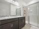 Bathroom featuring double sinks, granite countertops, and a glass-enclosed shower at 6533 Great Bear Dr, Lakeland, FL 33805