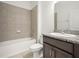 Bathroom featuring a tub and shower combo, granite countertops, and dark wood cabinets at 6533 Great Bear Dr, Lakeland, FL 33805