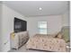 This carpeted bedroom features a television, dresser, a window for natural light, and a comfortable bed at 6769 Se 3Rd Loop, Ocala, FL 34472