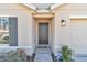 Close-up of the home's front door with a dark door, sidelight window and a small landscaped area at 6769 Se 3Rd Loop, Ocala, FL 34472
