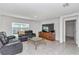 Comfortable living room features tile flooring, a large TV, and black leather reclining sofas at 6769 Se 3Rd Loop, Ocala, FL 34472