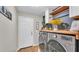 Functional laundry room with wood countertops, cabinets, and modern washer and dryer for convenience at 7144 Remington Oaks Loop, Lakeland, FL 33810