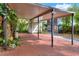 Large carport with parking space, featuring a storage shed and additional parking on brick pavers, plus mature trees at 810 Orange Park Ave, Lakeland, FL 33801
