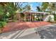 A large carport and storage shed in a backyard with full brick paving and lush landscaping at 810 Orange Park Ave, Lakeland, FL 33801
