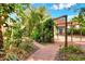 A lush, mature backyard featuring a brick walkway and large carport for multiple cars at 810 Orange Park Ave, Lakeland, FL 33801
