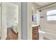 Bathroom and bedroom featuring a shower-tub combo and wooden vanity at 810 Orange Park Ave, Lakeland, FL 33801