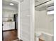 A view from the kitchen into the bathroom, which features a tub and shower with white tile and updated fixtures at 810 Orange Park Ave, Lakeland, FL 33801