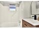 Modern bathroom features a sleek vanity with wood cabinets, white countertop, black faucet, and tiled shower/tub combo at 810 Orange Park Ave, Lakeland, FL 33801