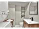 Modern bathroom with stacked washer and dryer, floating shelves, and a vanity sink at 810 Orange Park Ave, Lakeland, FL 33801