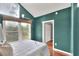 Bedroom featuring dark green walls, white trim, and a large window with a view to the outdoors at 810 Orange Park Ave, Lakeland, FL 33801