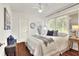 Bright bedroom featuring a large window, ceiling fan, and hardwood floors, creating a cozy and inviting space at 810 Orange Park Ave, Lakeland, FL 33801
