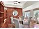 Dining room with wood paneling, glass table, and cozy seating area by the windows at 810 Orange Park Ave, Lakeland, FL 33801