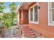 Exterior view of the rear of home, showcasing steps, siding, and a cozy walkway at 810 Orange Park Ave, Lakeland, FL 33801