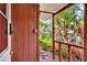 Home's front porch featuring a wood railing, view of yard and a red-stained door at 810 Orange Park Ave, Lakeland, FL 33801