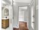 Hallway with wood flooring and neutral paint leads to a bathroom and another room with a white closet at 810 Orange Park Ave, Lakeland, FL 33801