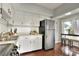 Bright kitchen with white cabinets, black hardware, stainless steel refrigerator, and hardwood floors at 810 Orange Park Ave, Lakeland, FL 33801