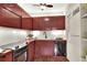 Retro kitchen with dark wood cabinets, laminate countertops, and modern appliances at 810 Orange Park Ave, Lakeland, FL 33801