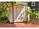 Exterior view of the storage shed with vertical siding, located in a backyard with brick paving and lush greenery at 810 Orange Park Ave, Lakeland, FL 33801