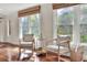Cozy sitting room with hardwood floors, two chairs, and two bright windows with woven blinds at 810 Orange Park Ave, Lakeland, FL 33801