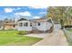 Charming single-story home with light siding, brown trim, and a well-manicured front lawn at 827 Sikes Blvd, Lakeland, FL 33815