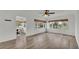 Spacious living room with wood-look floors, ceiling fan, and large windows for plenty of natural light at 827 Sikes Blvd, Lakeland, FL 33815