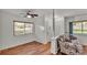 Cozy living room with wood floors, ceiling fan, and natural light from a large window at 8303 Waterview Way # 8303, Winter Haven, FL 33884