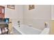 Bathroom features a clean white tub, neutral wall color and an adjacent desk area at 8303 Waterview Way # 8303, Winter Haven, FL 33884