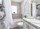 Well-lit bathroom with grey tile backsplash, white cabinets, granite countertop, tub with shower, and white window trim at 1001 Aruba Ave, Mulberry, FL 33860