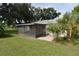 An exterior shot of the backyard, with a screened patio, green grass and palm trees at 1065 Jordan Rd, Lakeland, FL 33811