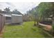 Fenced backyard featuring a storage shed, lush lawn, mature landscaping, and screened in patio at 1065 Jordan Rd, Lakeland, FL 33811