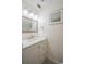 Well-lit bathroom features a vanity with a white countertop, modern fixtures, and decorative wall art at 1100 Lowry Ave # 51, Lakeland, FL 33801