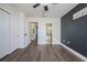 Bedroom with dark accent wall, new floors, ceiling fan, and doorway to bathroom at 1100 Lowry Ave # 51, Lakeland, FL 33801